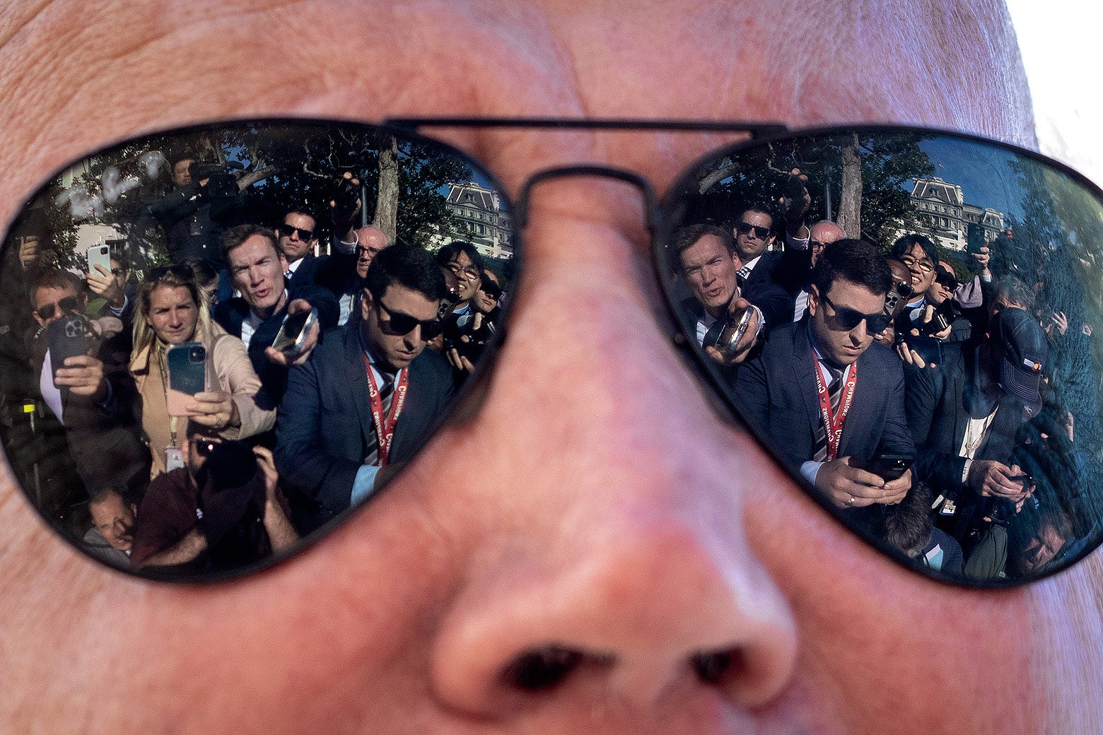 Reporters are reflected in the sunglasses of U.S. President Joe Biden .