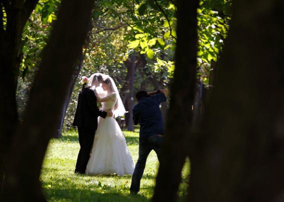 A photographer takes wedding pictures of a couple at a park, August 7, 2013. 