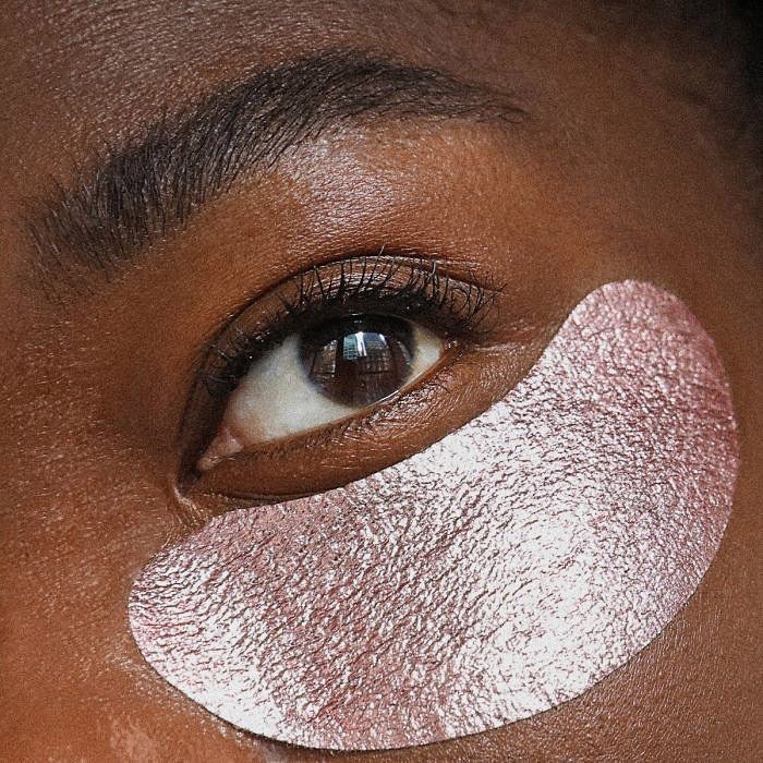 A close-up on a woman’s face with an eye mask under her eye.