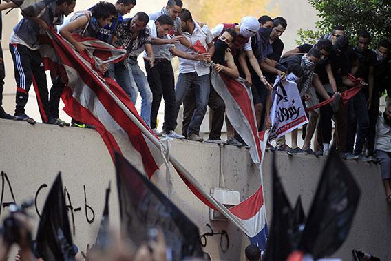 Protesters destroy an American flag pulled down from the U.S. embassy in Cairo September 11, 2012. 