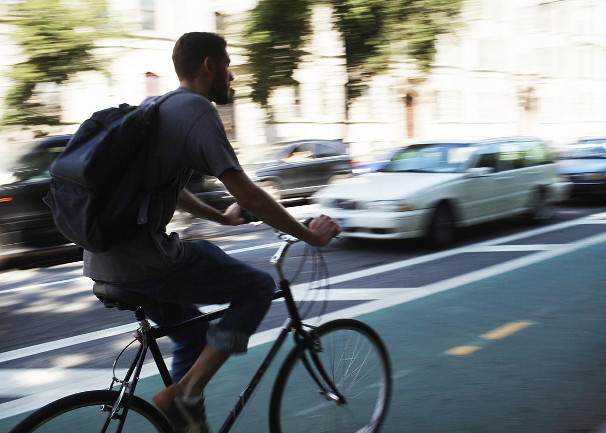 A man rides his bike along a bike lane on Prospect Park West in the Brooklyn borough of New York City. 