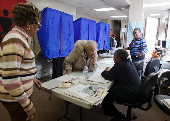 A voter signs in at her polling place inside the Concerned Black Men’s office in November 2012 in North Philadelphia