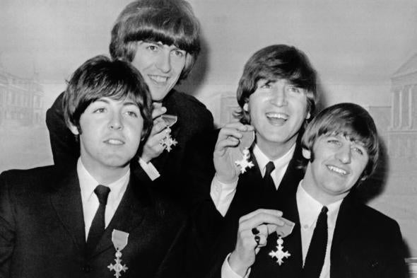 The Beatles hold up their British Empire Medals following their investiture on Oct. 26, 1965, at Buckingham Palace in London.