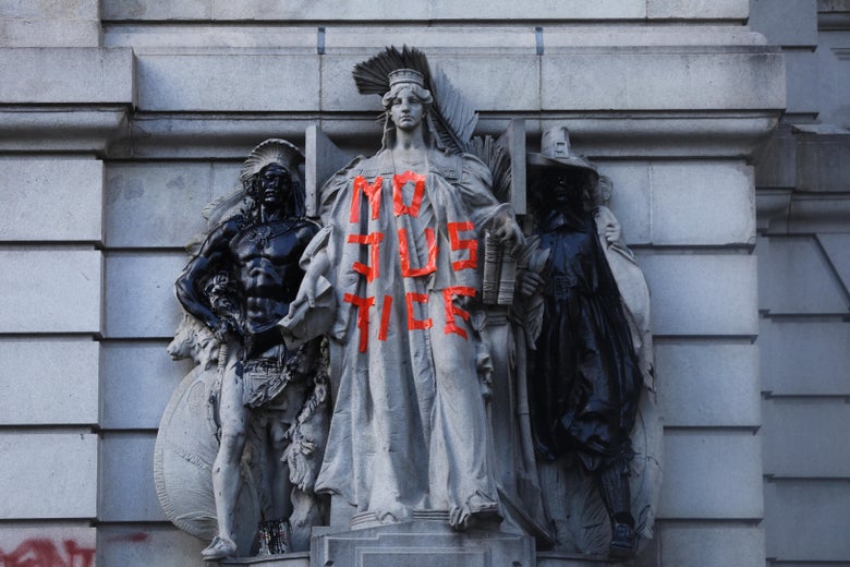 Graffiti in in tape marks figures adorning a historic building near where protesters affiliated with Black Lives Matter (BLM) and other groups have congregated in a park outside of City Hall in Lower Manhattan on June 30, 2020 in New York City. The growing group of protesters clashed with police in the early morning hours as tensions increase ahead of a City Council vote on New York’s budget, which includes the police department budget. Similar to the Occupy Wall Street movement that took over Zuccotti Park for months, the group is now making food, medical and information stations available to assist those protesters that want to stay.  (Photo by Spencer Platt/Getty Images)