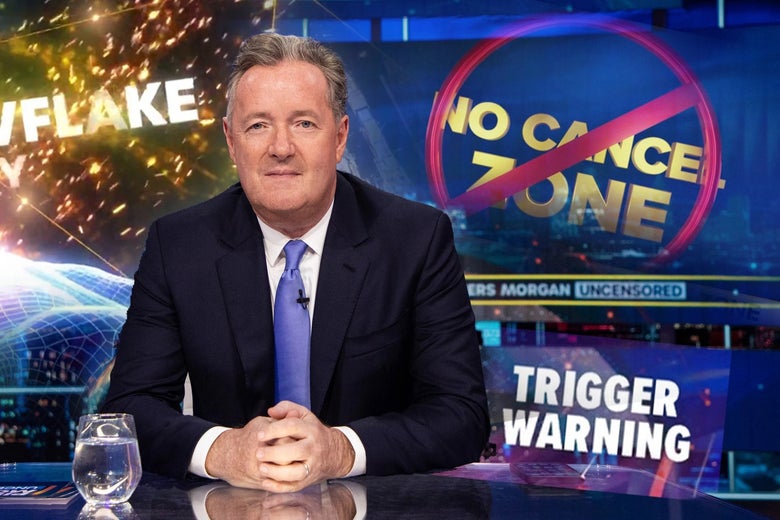 Piers Morgan smiles and clasps his hands at the desk on his show beside graphics that say "No Cancel Zone" and "Trigger Warning"