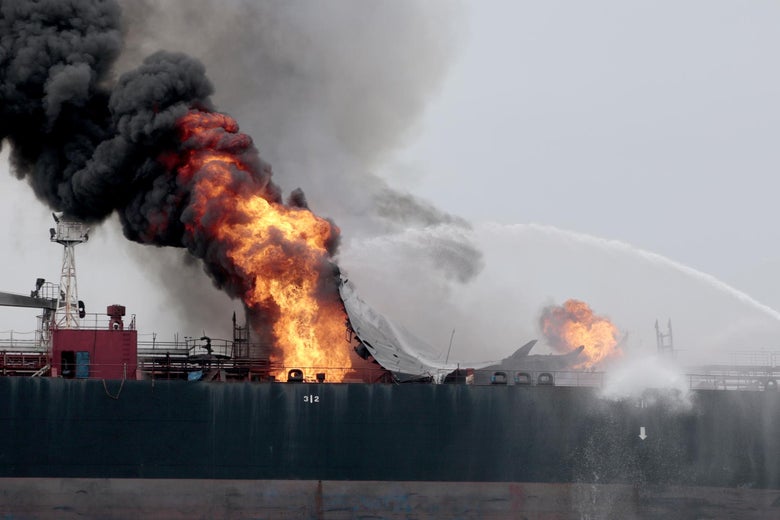 A fire on an oil tanker gets doused by a stream of water.