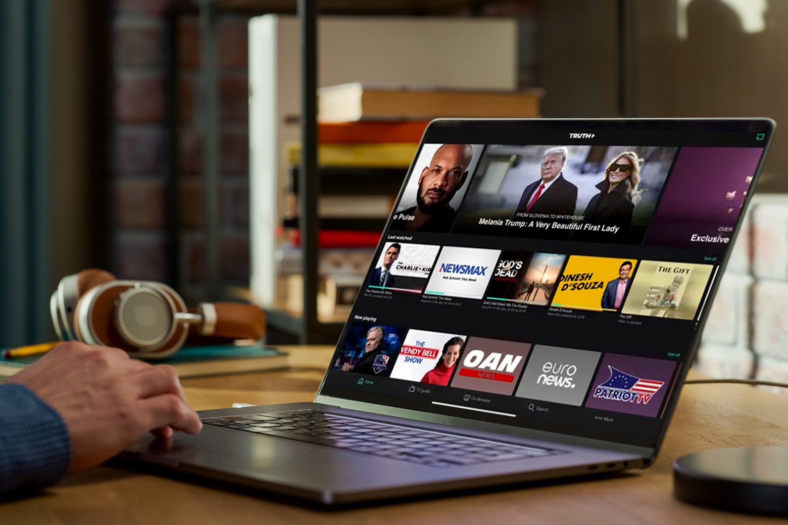 Un hombre controla su computadora portátil con la página de inicio de la aplicación de transmisión de Truth Social en la pantalla.