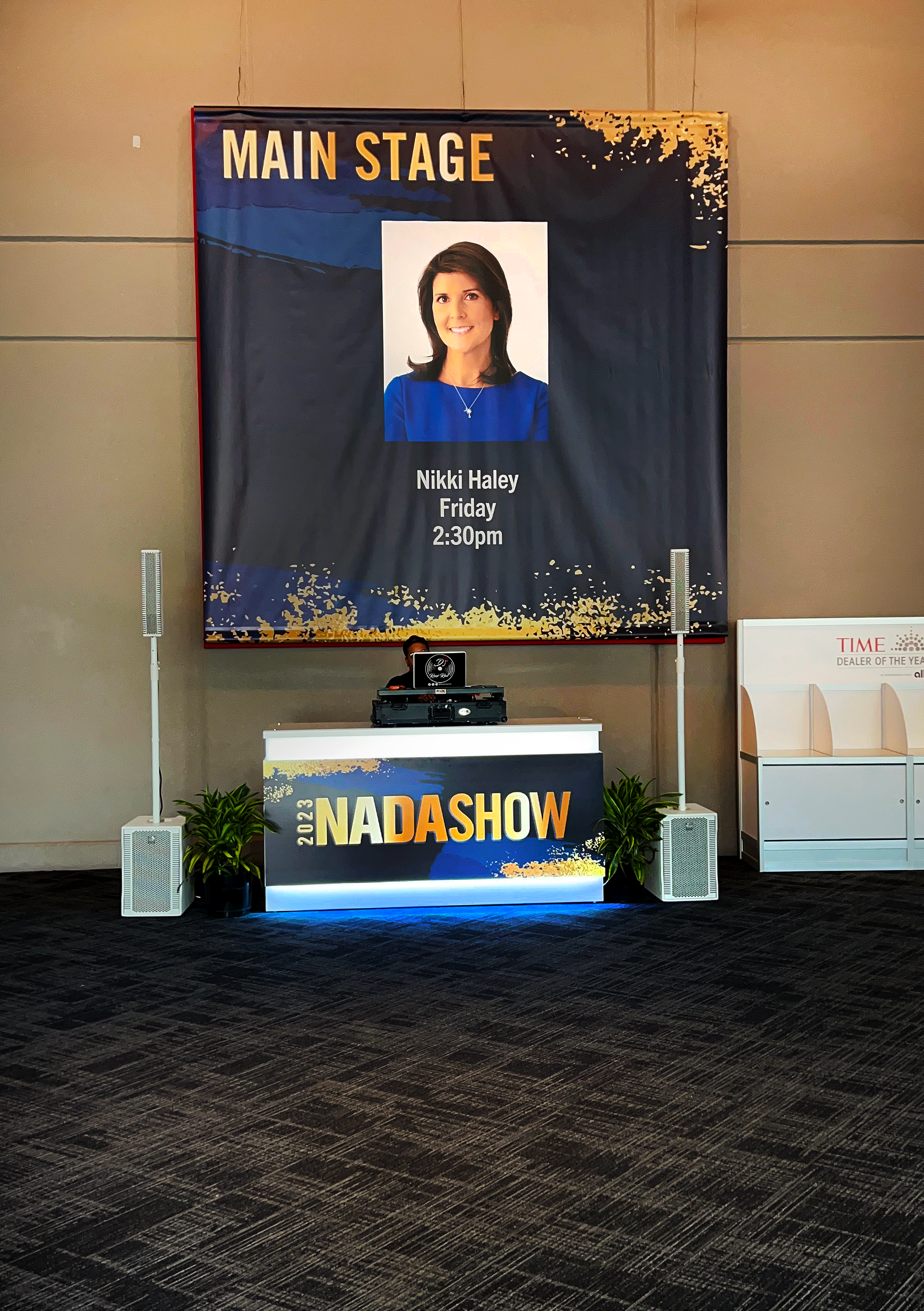 A poster hanging on a wall that says "Main Stage: Nikki Haley, Friday, 2:30 p.m."