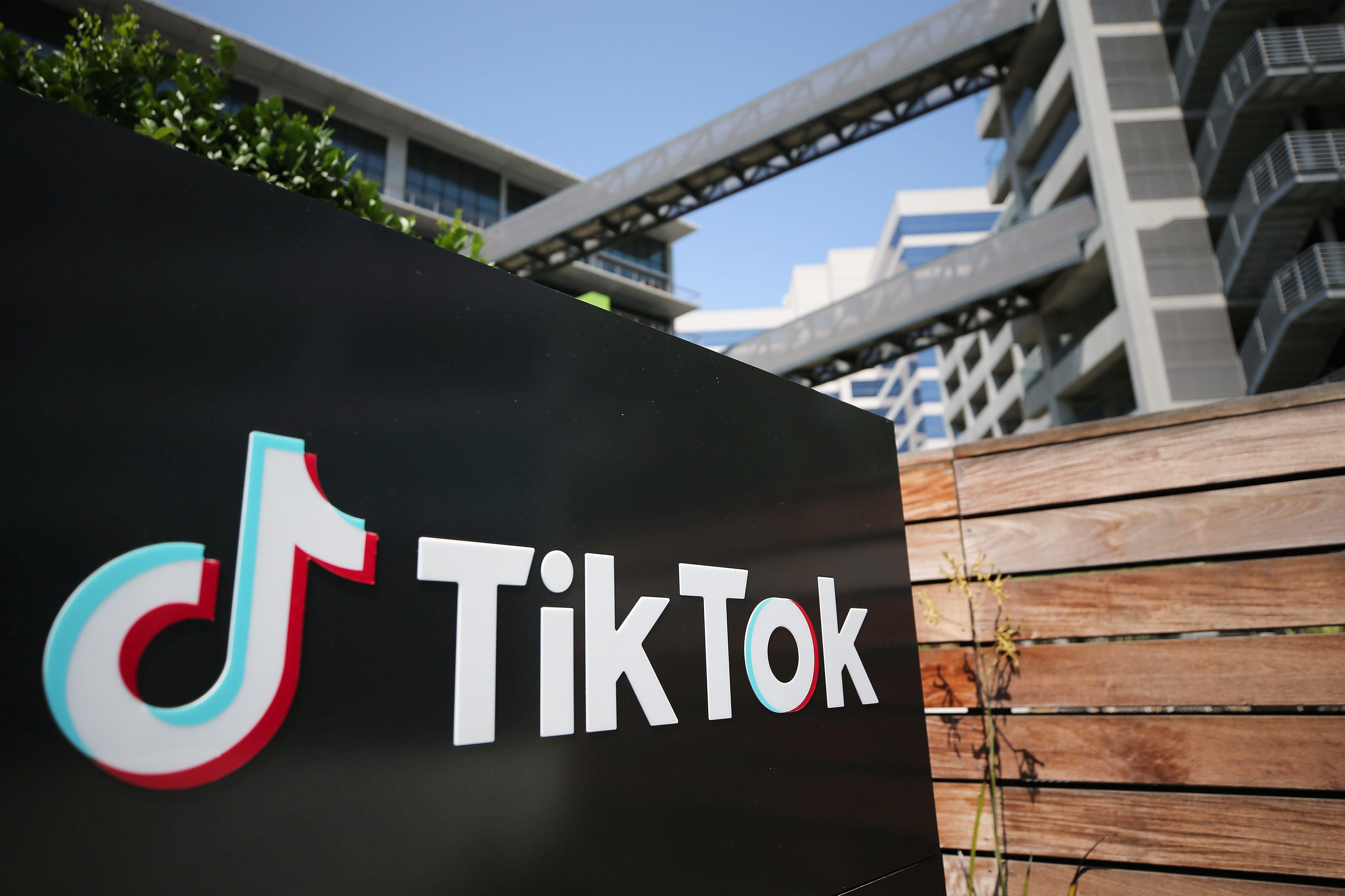 The TikTok logo, on a black surface with the words TikTok in white and a music note next to it, outside of a California office.