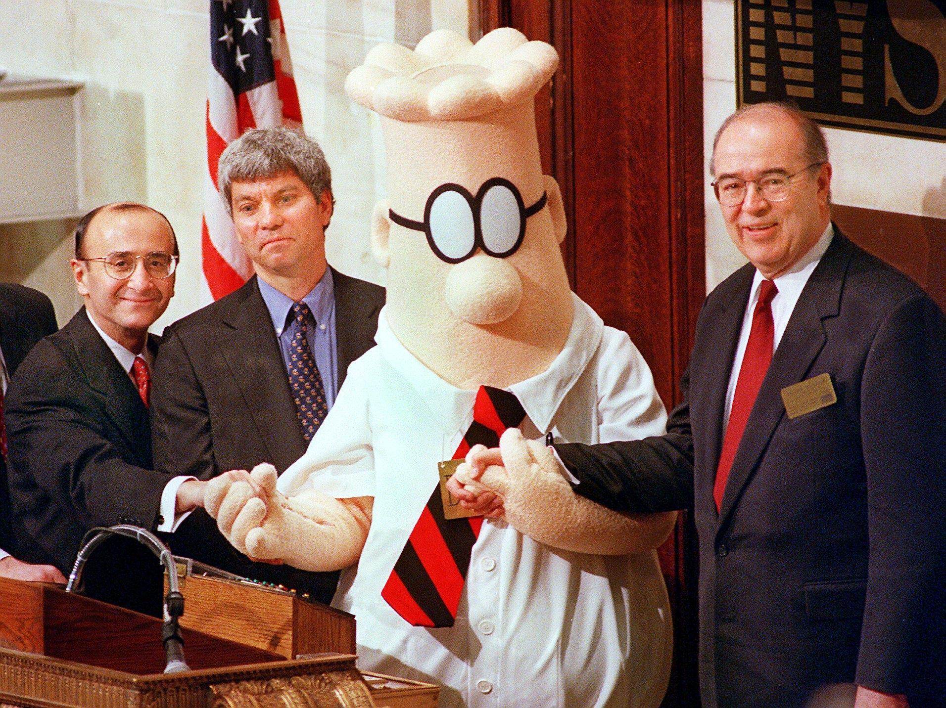 NEW YORK, UNITED STATES:  Dilbert, the comic strip character struggling to make his way up the corporate ladder, is joined by William Burleigh (R), President and Chief Executive Officer of the E.W. Scripps Company, Douglas Stern (2nd from L), Pres. and CEO of United Media, and Richard Grasso (L), Chairman of the New York Stock Exchange, to ring the opening bell as part of the activities to promote the launch of Dilbert's new television show 25 January.   AFP PHOTOS/Henny Ray ABRAMS (Photo credit should read HENNY RAY ABRAMS/AFP via Getty Images)