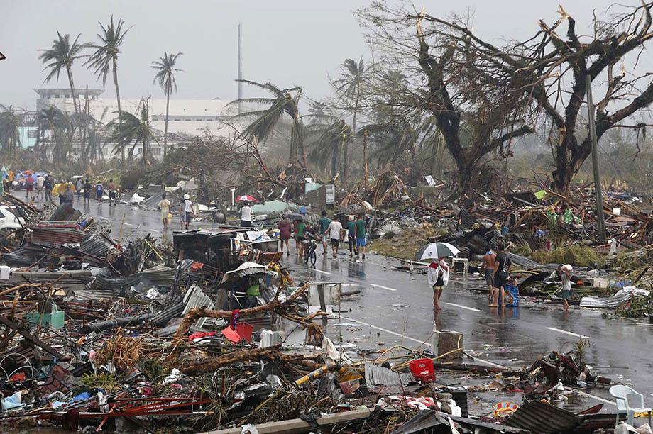 Residents walk on a road littered with debris after Super Typhoon Haiyan battered Tacloban city in central Philippines November 10, 2013. 