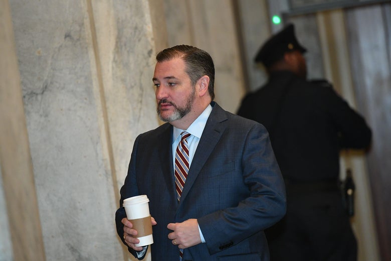 Cruz walks in a hallway, holding a coffee cup.