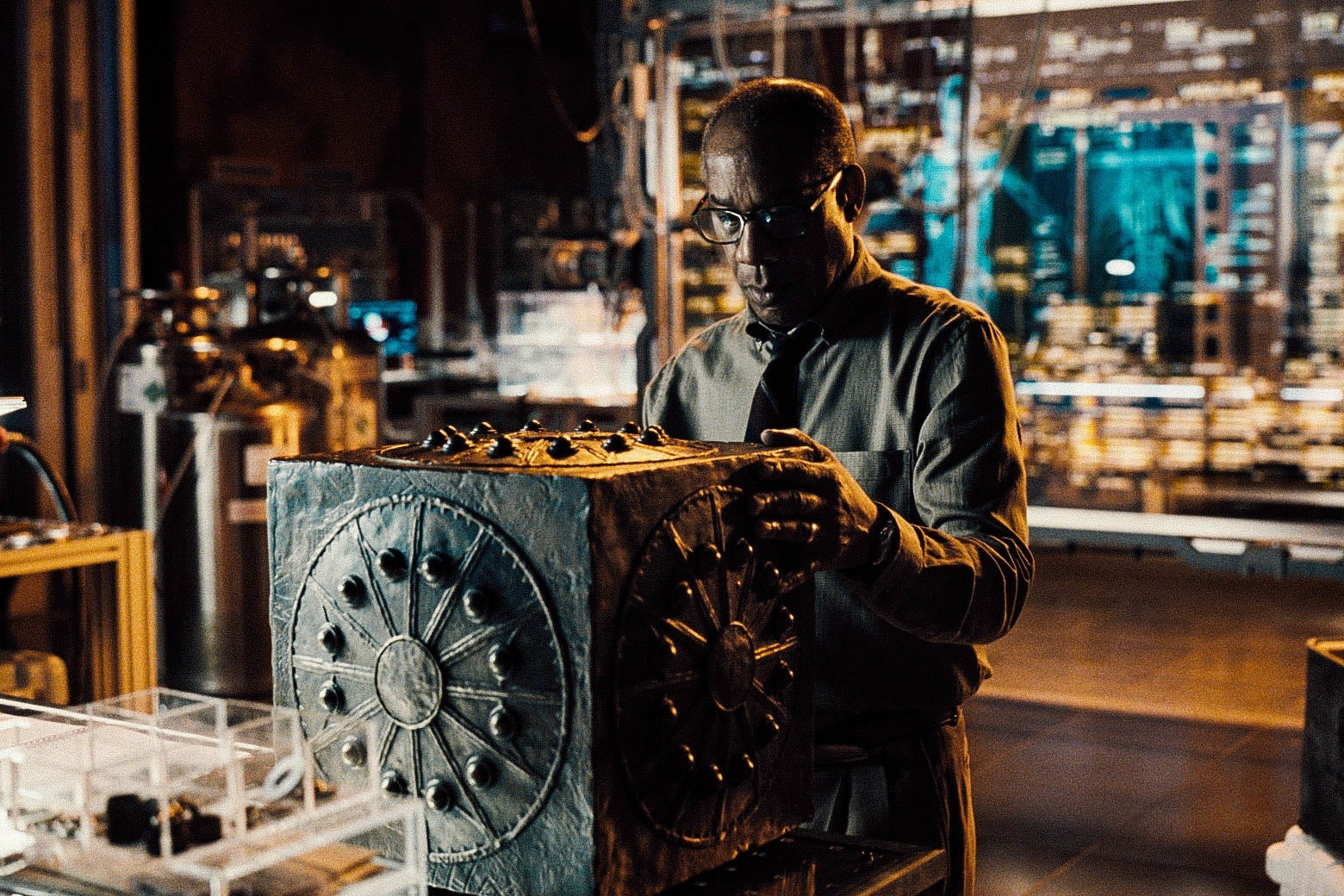 A man looks at a big black box.