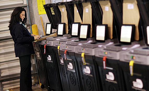 An election official goes through the steps to check voting machines for accuracy