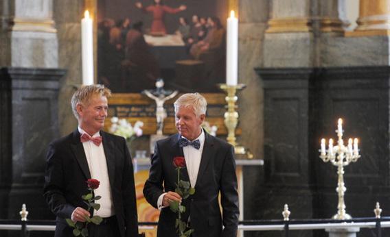 Stig Ellins, left, and his partner Steen Andersen pose with a rose after their wedding at Frederiksberg church in Copenhagen in June.