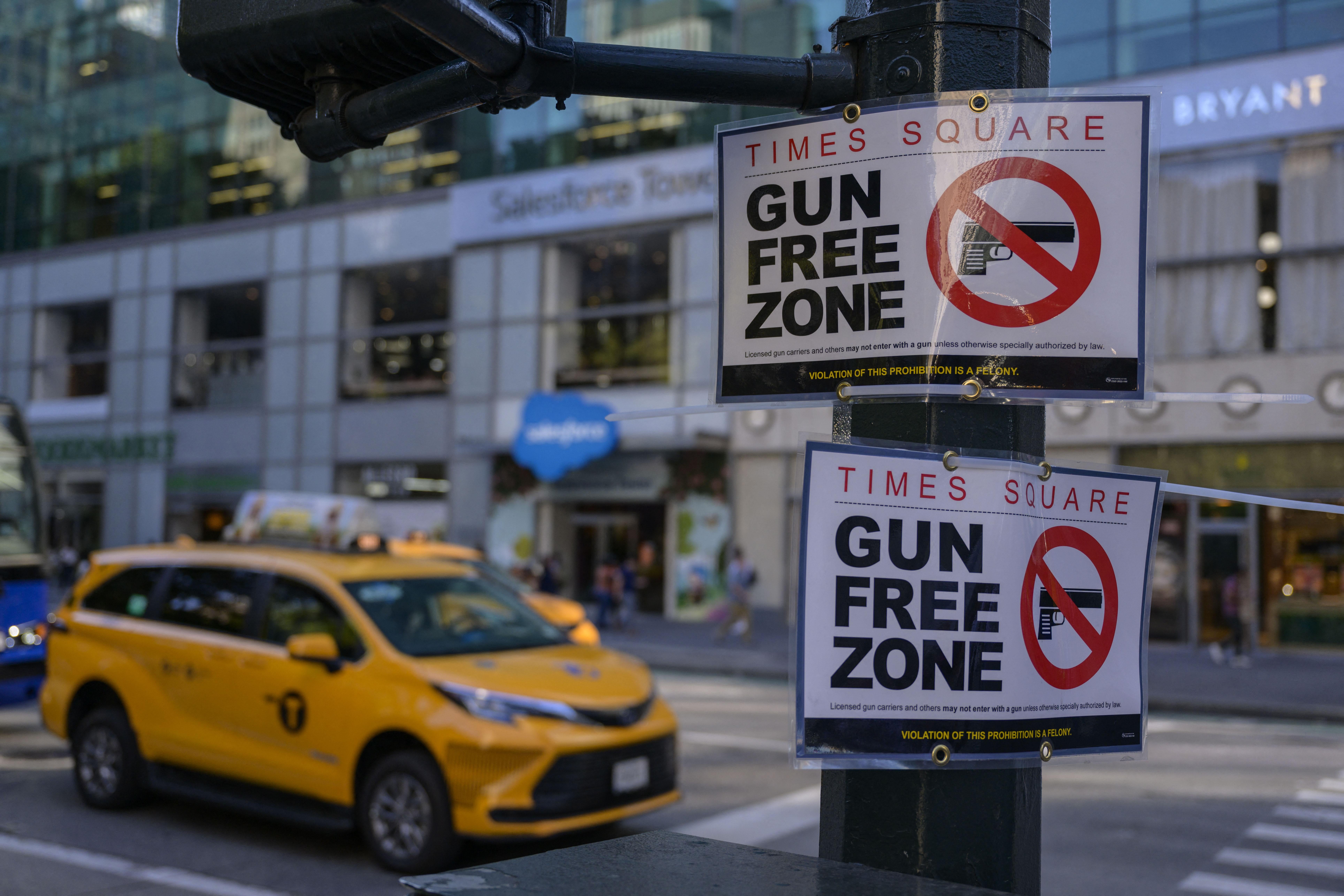 Gun Free Zone signs with cabs in the background.