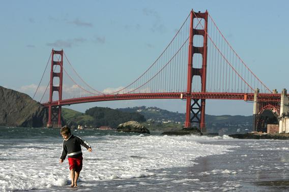 A boy plays in the water at Baker Beach near the Golden Gate Bridge March 25, 2005 in San Francisco, California.