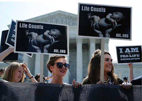 Anti-abortion demonstrators wait for the U.S. Supreme Court ruling in the Hobby Lobby.
