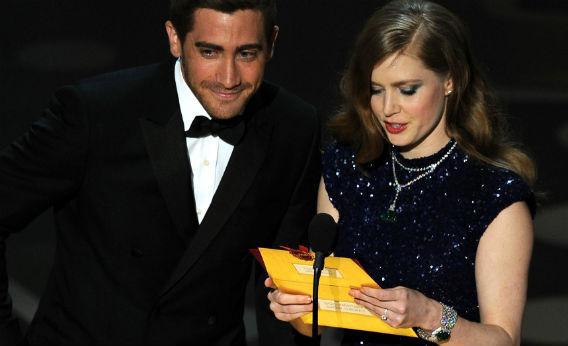 Jake Gyllenhaal and Amy Adams open an envelope at the Oscars.