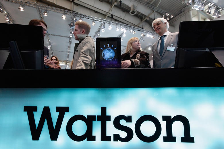 People stand behind a booth that says Watson.
