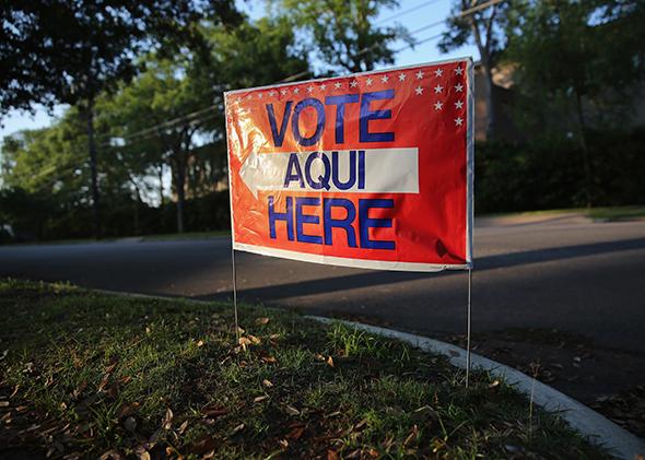 A bilingual sign draws voters to a polling center at a public library ahead of local elections on April 28, 2013, in Austin, Texas.