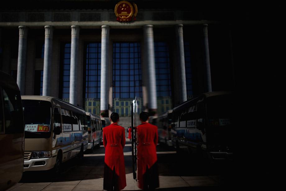 Hotel guide for delegates waits outside the Great Hall of the People during a  presidium meeting after a pre-opening session of the National People's Congress, China's parliament, on March 4, 2013 in Beijing, China. 