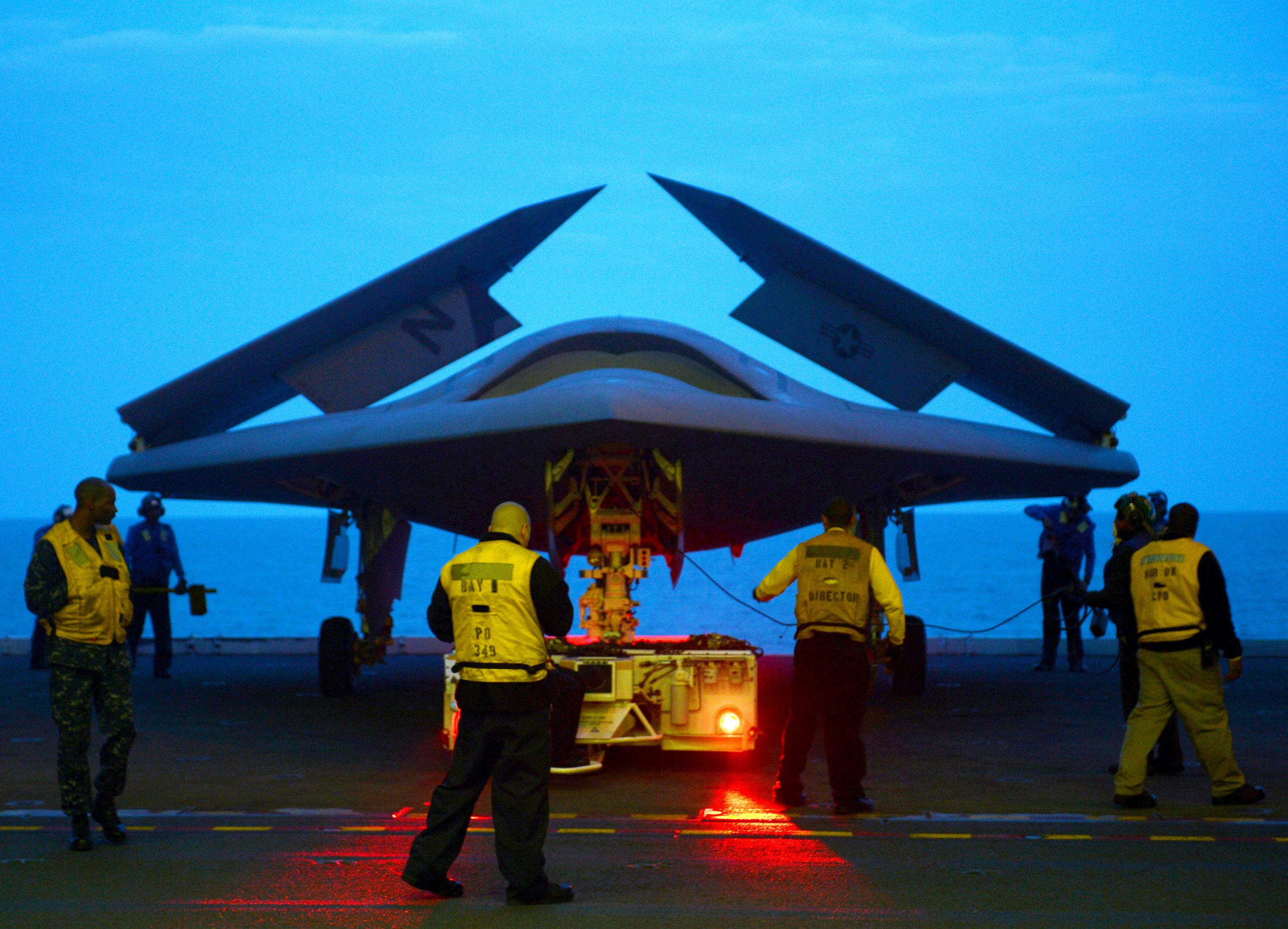 An X-47B Unmanned Combat Air System (UCAS) demonstrator is towed into the hangar bay of the aircraft carrier USS George H.W. Bush (CVN 77) May 13, 2013, in the Atlantic Ocean.
