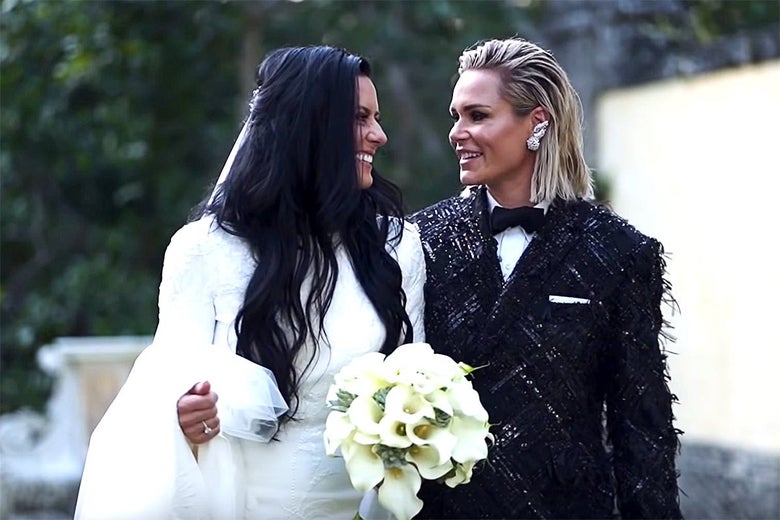 Ali Krieger and Ashlyn Harris stare and smile at each other in their wedding dress and wedding suit, respectively.