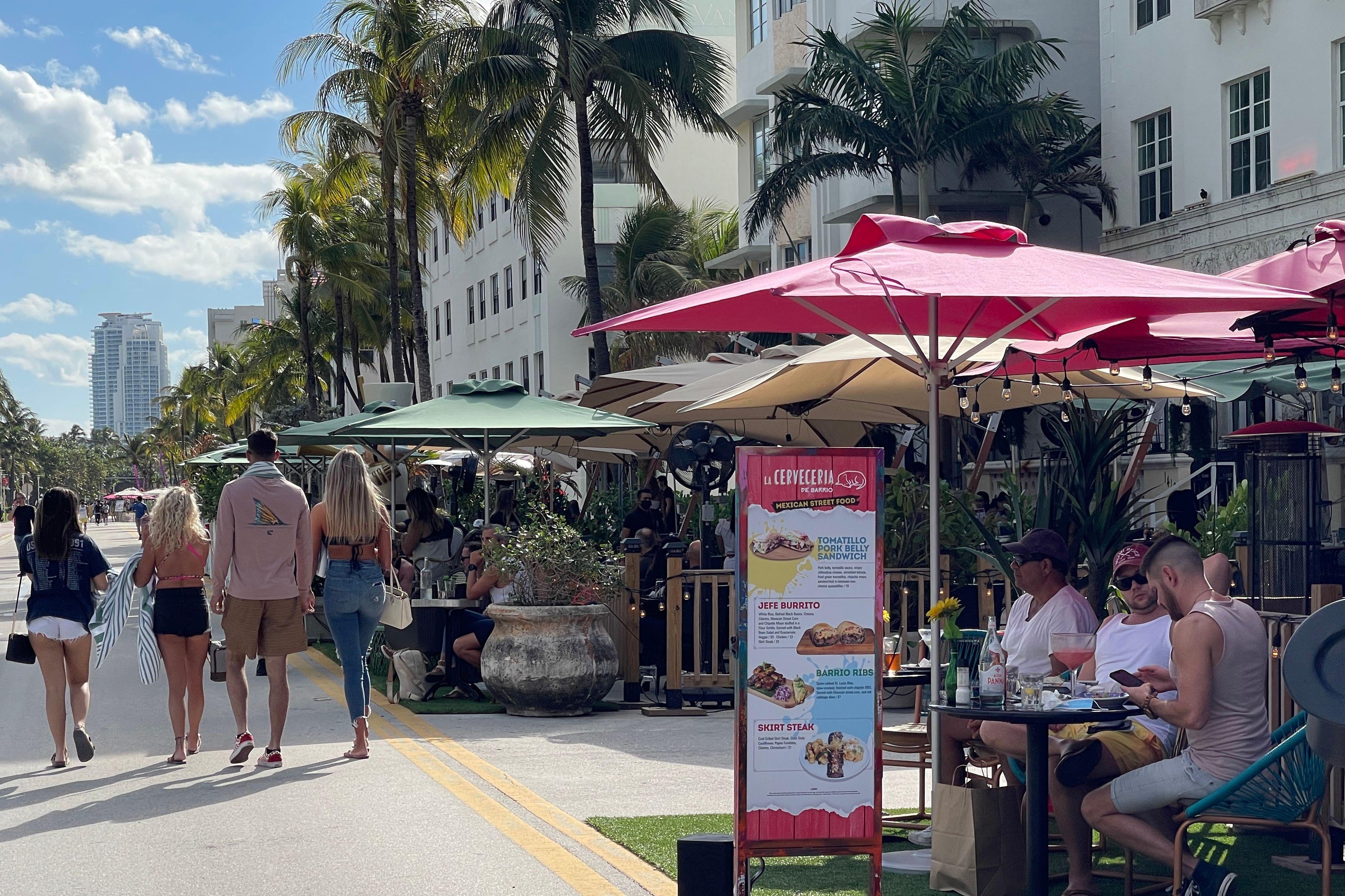 People enjoy food sitting on the outdoor area of Ocean Drive restaurants  in South beach, Florida.