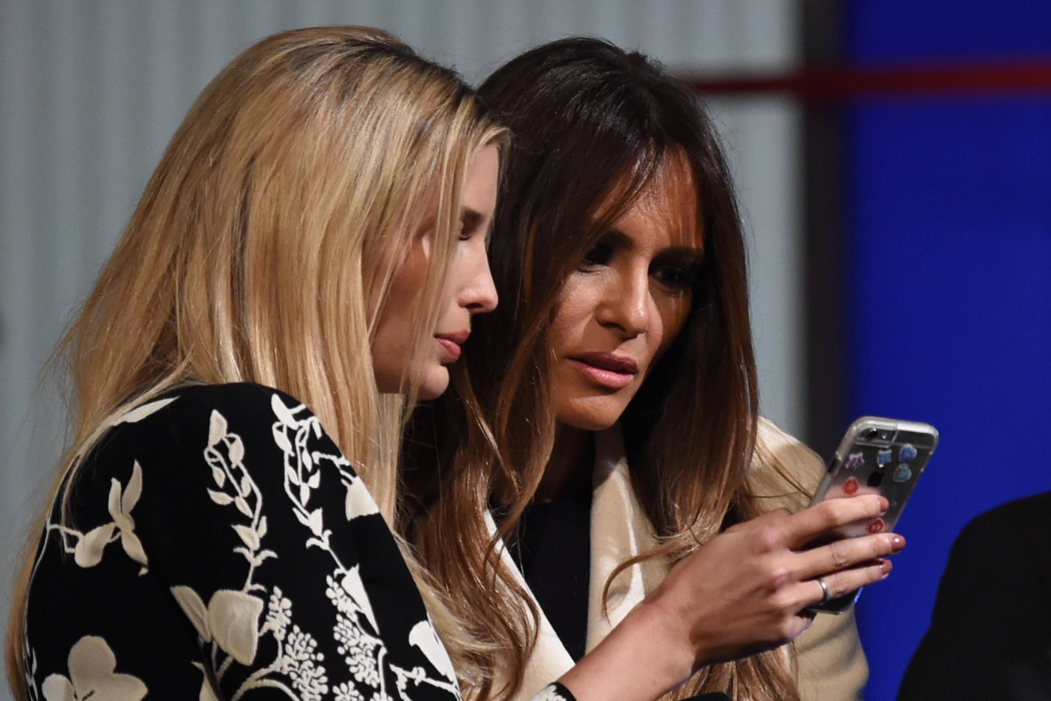 Ivanka and Melania Trump look at a smart phone after the Republican Presidential debate in Charleston, South Carolina on Jan. 14, 2016.