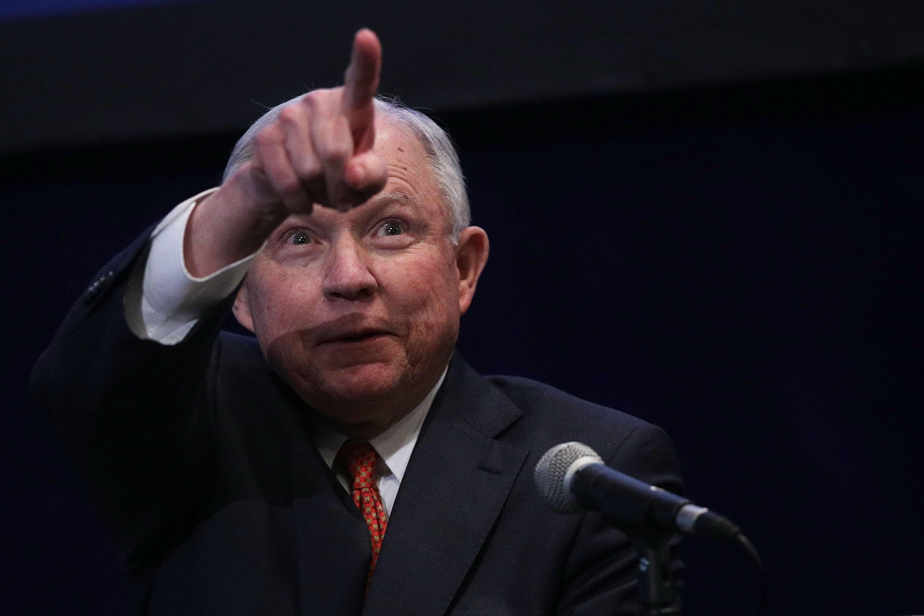 Attorney General Jeff Sessions points from behind a microphone during an event in Washington, DC. 