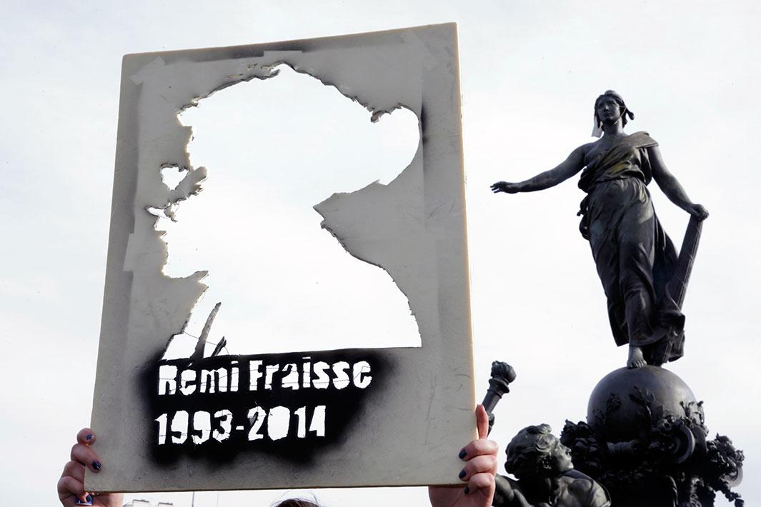 A student holds a cutout portrait of Remi Fraisse during a demonstration at the Place de la Nation in Paris on Nov. 13, 2014, against "police brutality" and in memory of the 21-year-old environmentalist who died during a violent standoff last month between police and ecology protesters seeking to prevent construction of a dam in Sivens