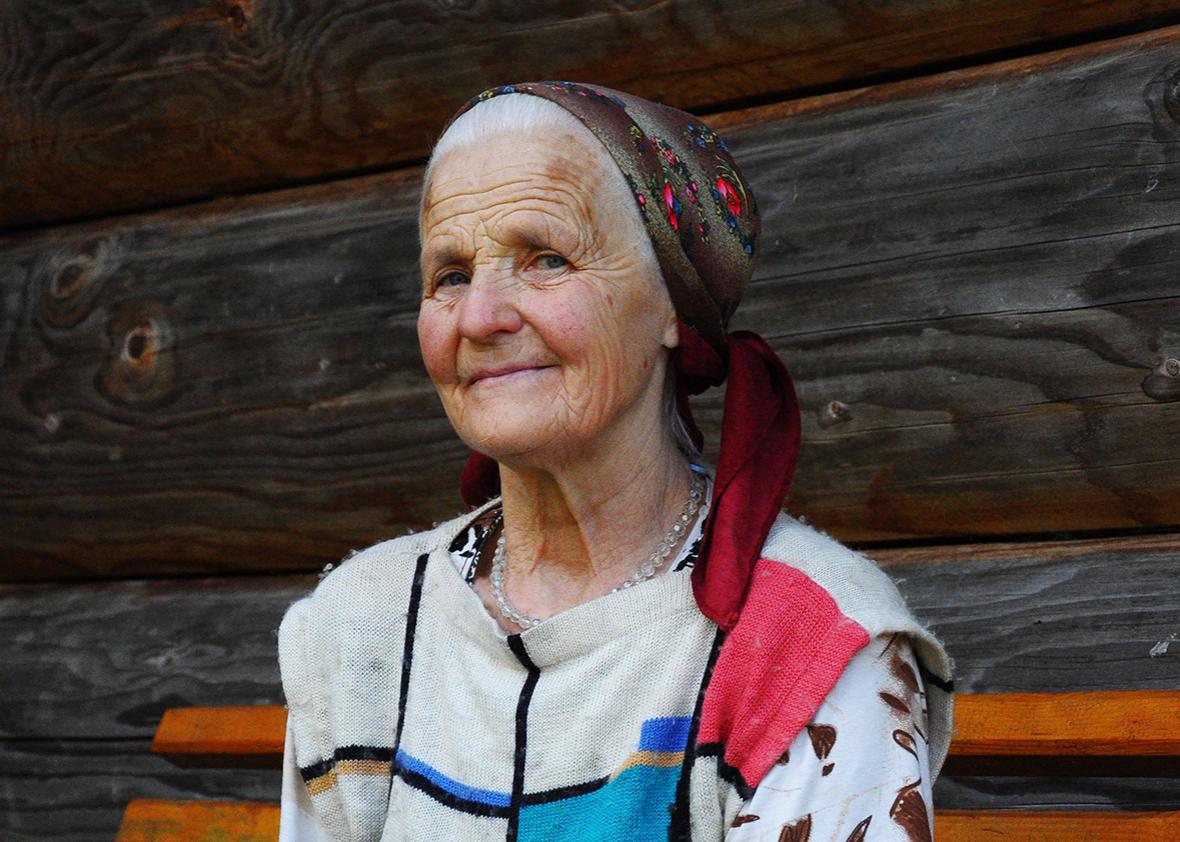 Pani Maria, 73, the matriarch of the Illyuk family, outside her cottage above the village of Dzembronya in the Carpathian Mountains.