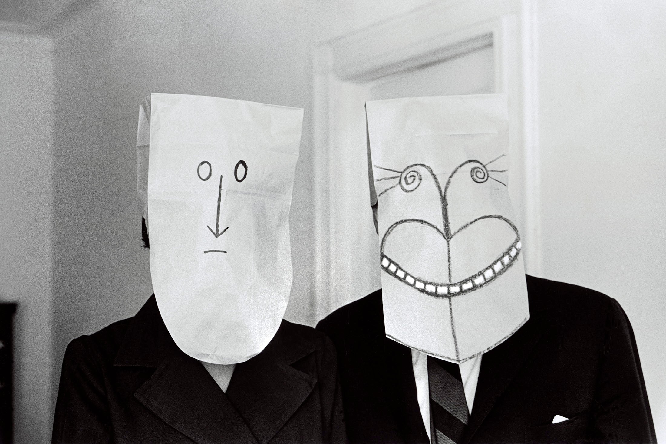 Two people wearing masks, one smiling, one frowning.