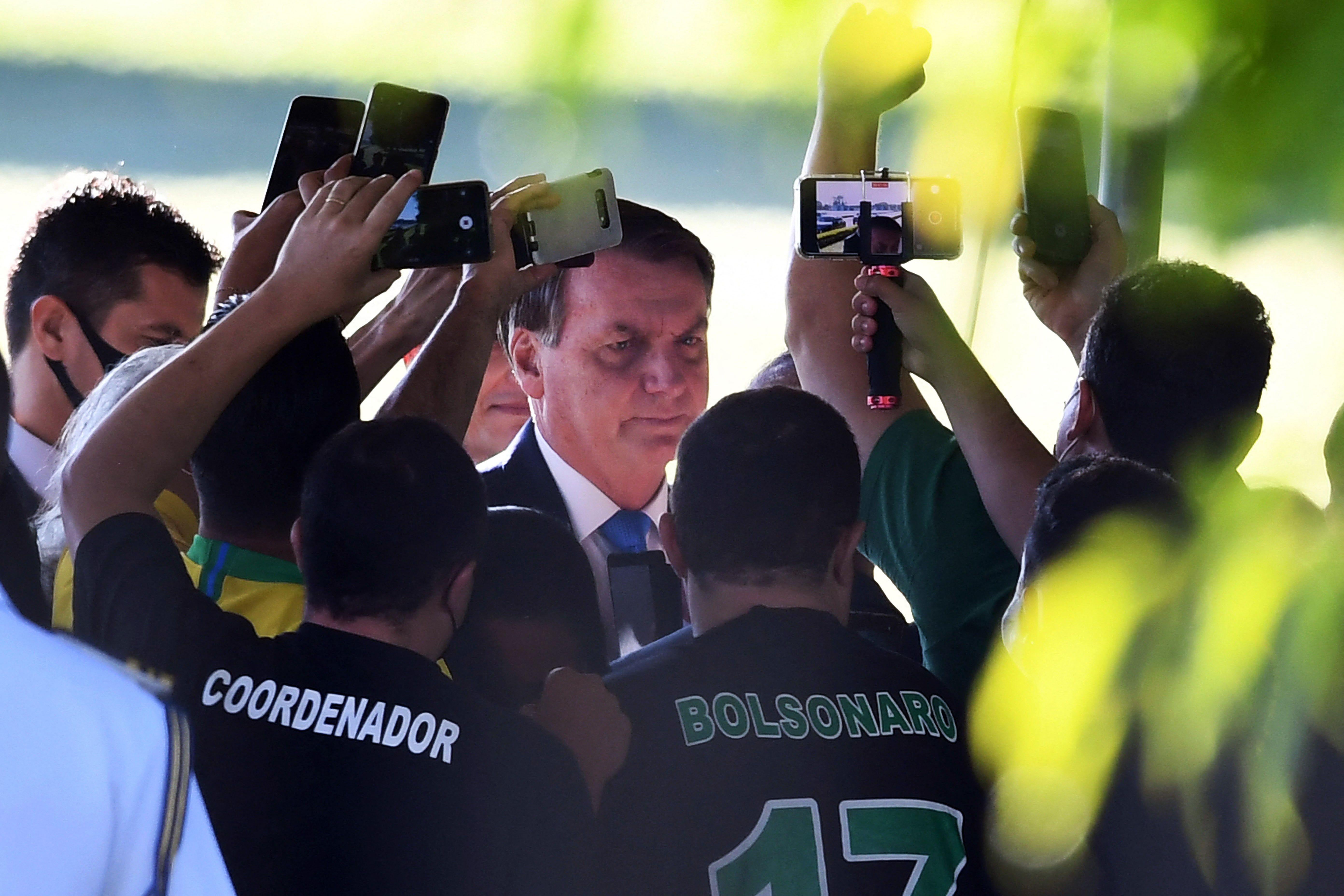 Bolsonaro thronged by people recording him on cellphones