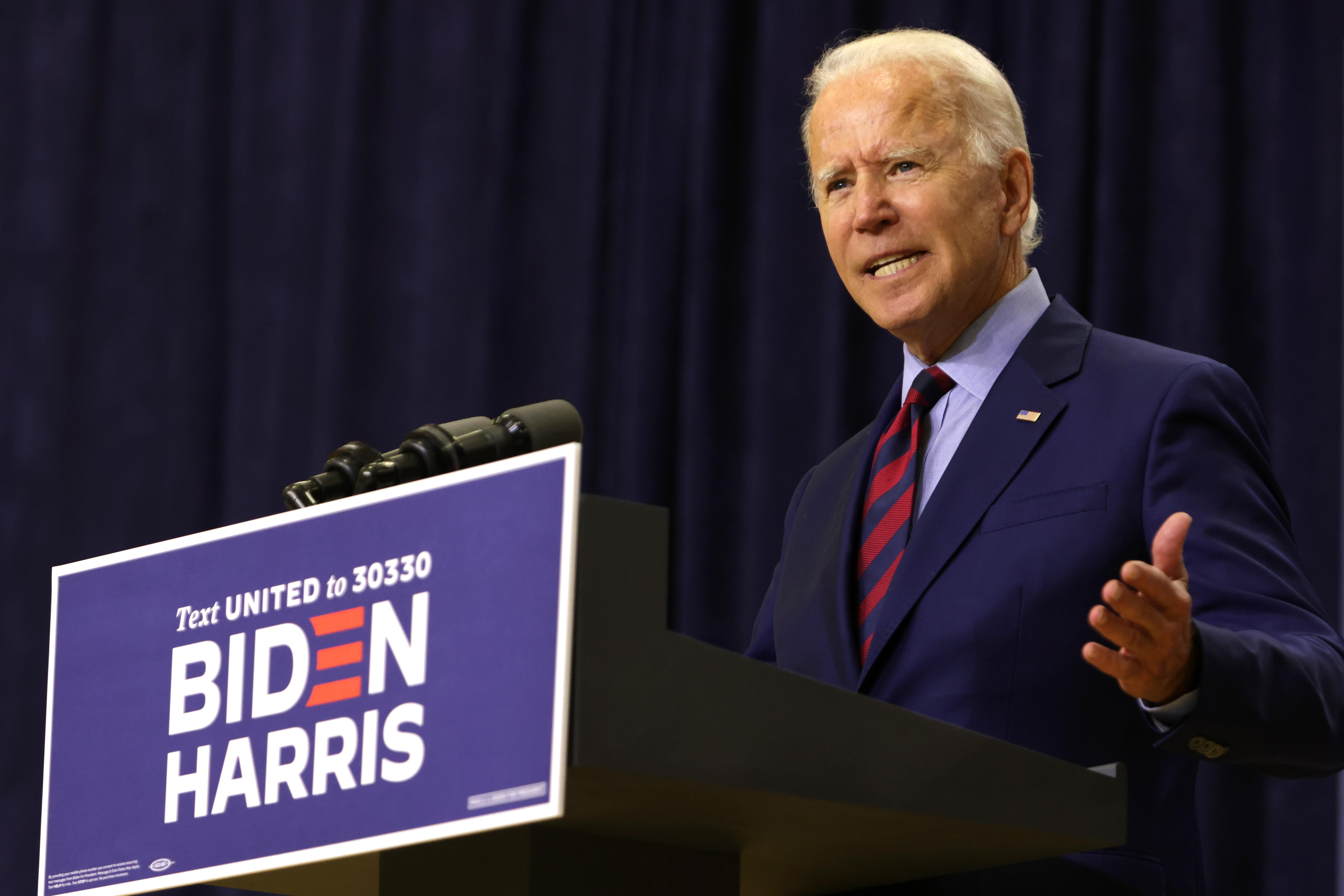 Biden speaks at a lectern carrying the Biden-Harris campaign logo.