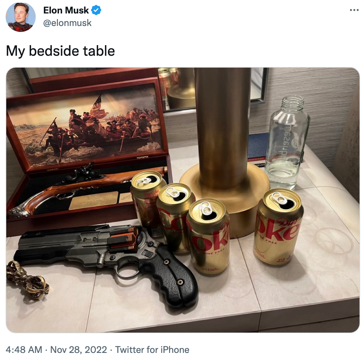 A tweet from Elon Musk, showing his bedside table with some guns and also four cans of Caffeine Free Diet Coke on it.