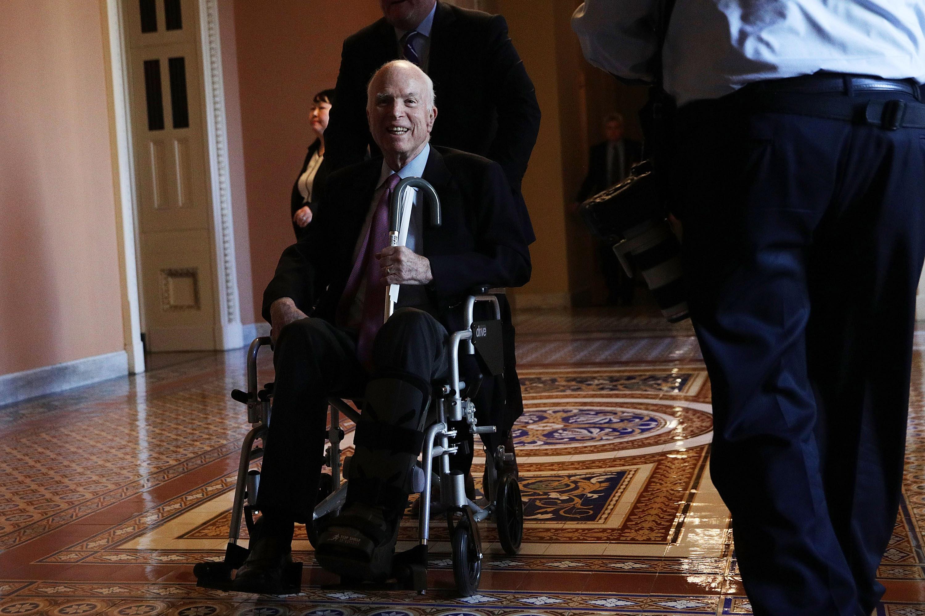 WASHINGTON, DC - DECEMBER 01:  U.S. Sen. John McCain (R-AZ) passes by on a wheelchair in a hallway at the Capitol December 1, 2017 in Washington, DC. Senate GOPs indicate that they have enough votes to pass the tax reform bill.  (Photo by Alex Wong/Getty Images)