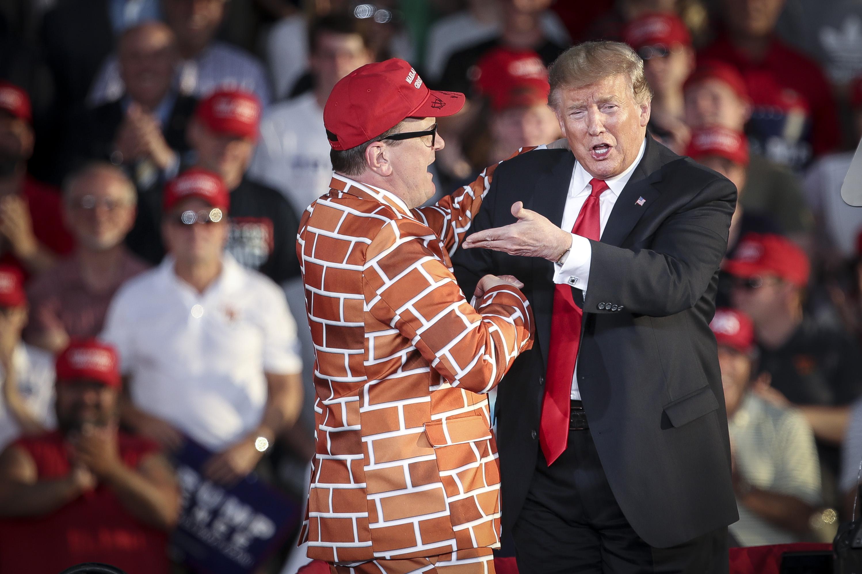 President Donald Trump calls up Blake Marnell, wearing a jacket with bricks representing a border wall, to the stage during a campaign rally at Williamsport Regional Airport, May 20, 2019 in Montoursville, Pennsylvania. 