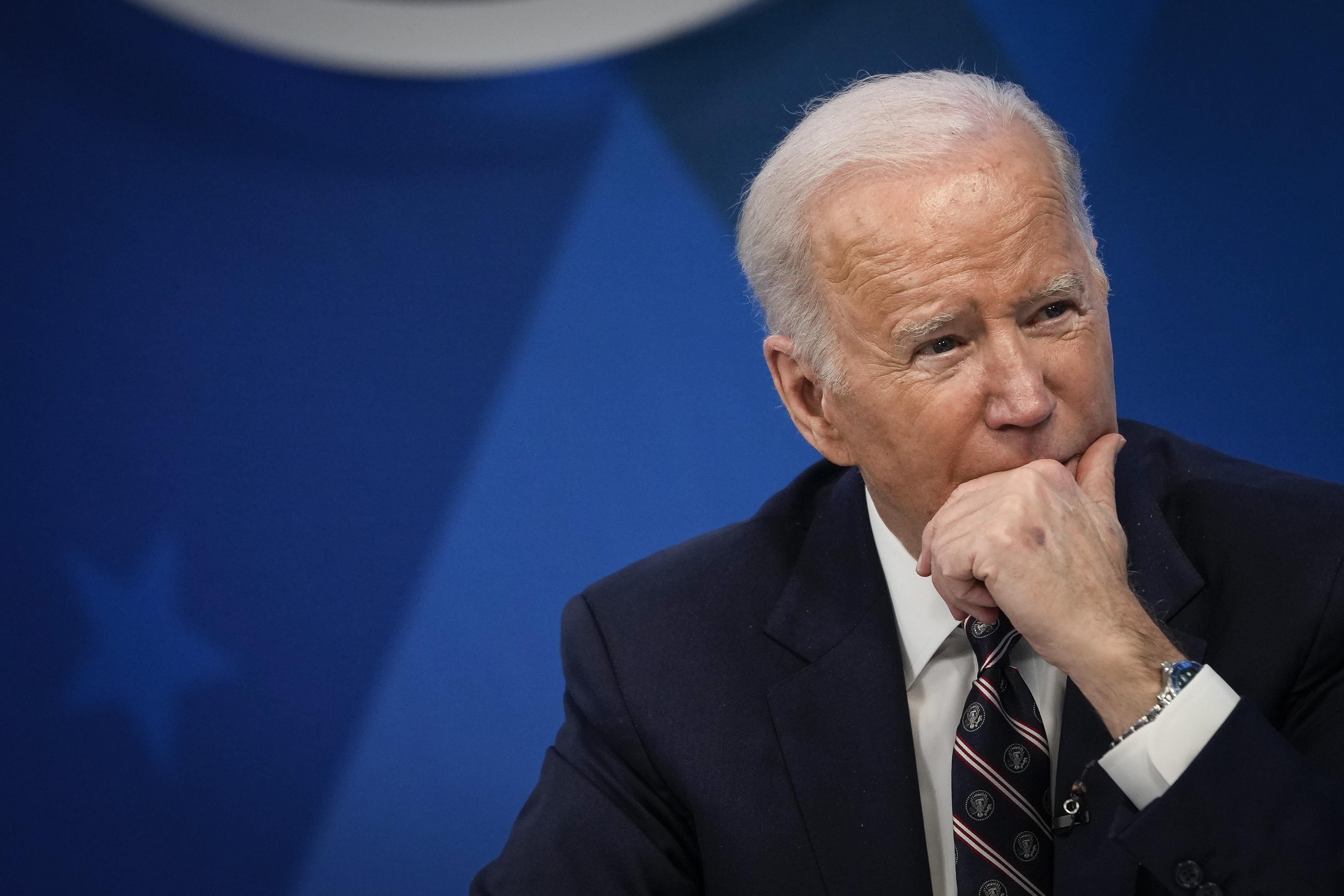 Joe Biden rests his chin in his hand.