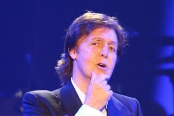 Paul McCartney onstage with a hand on his chin as if in contemplation.