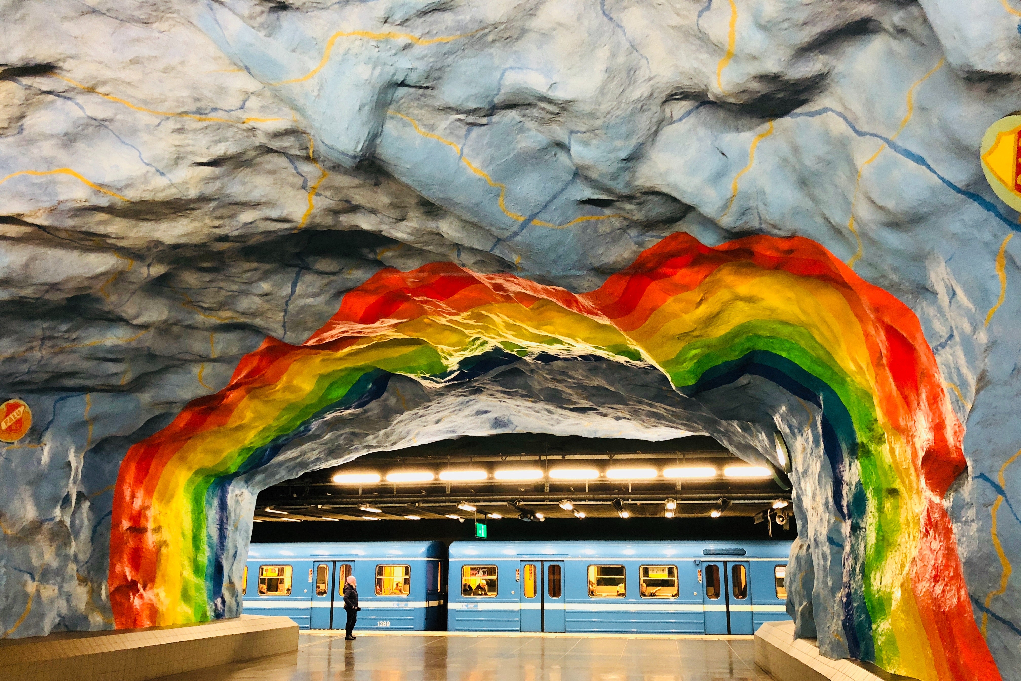 A rainbow tunnel opening onto a Stockholm subway platform.