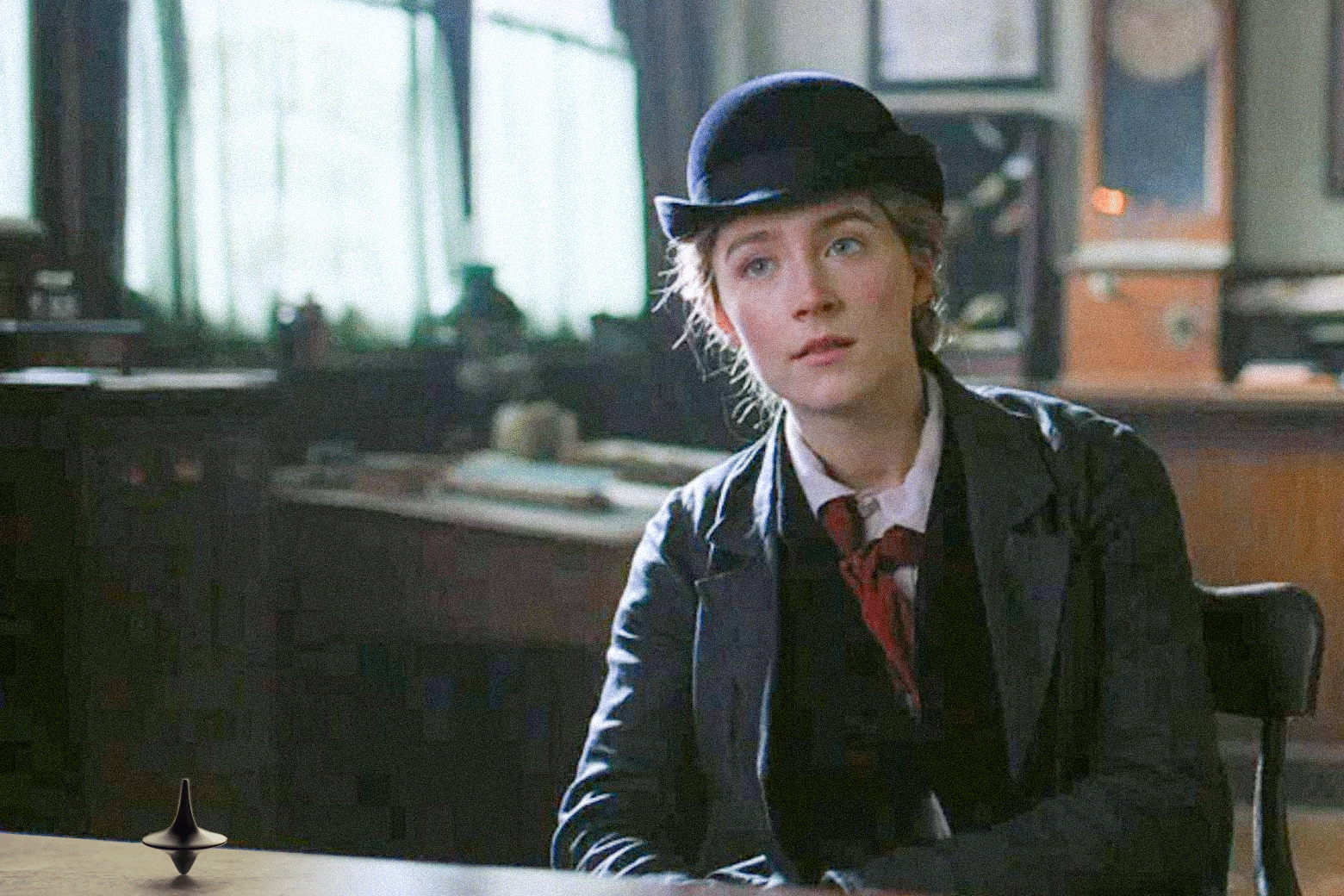 GIF of Saoirse Ronan as Jo while the Inception top spins endlessly on the table in front of her.