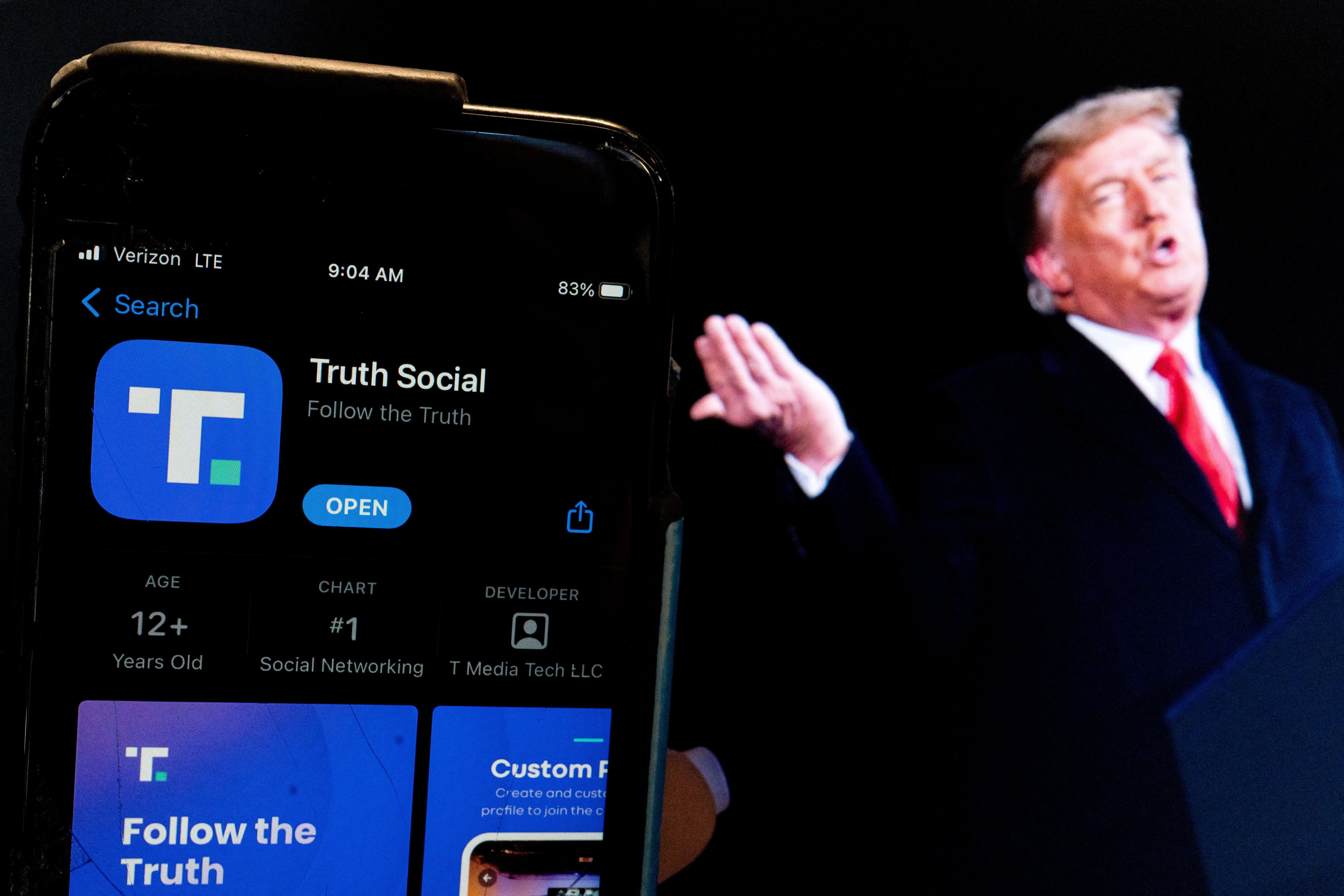 This photo illustration shows an image of former President Donald Trump next to a phone screen that is displaying the Truth Social app, in Washington, DC, on February 21, 2022.