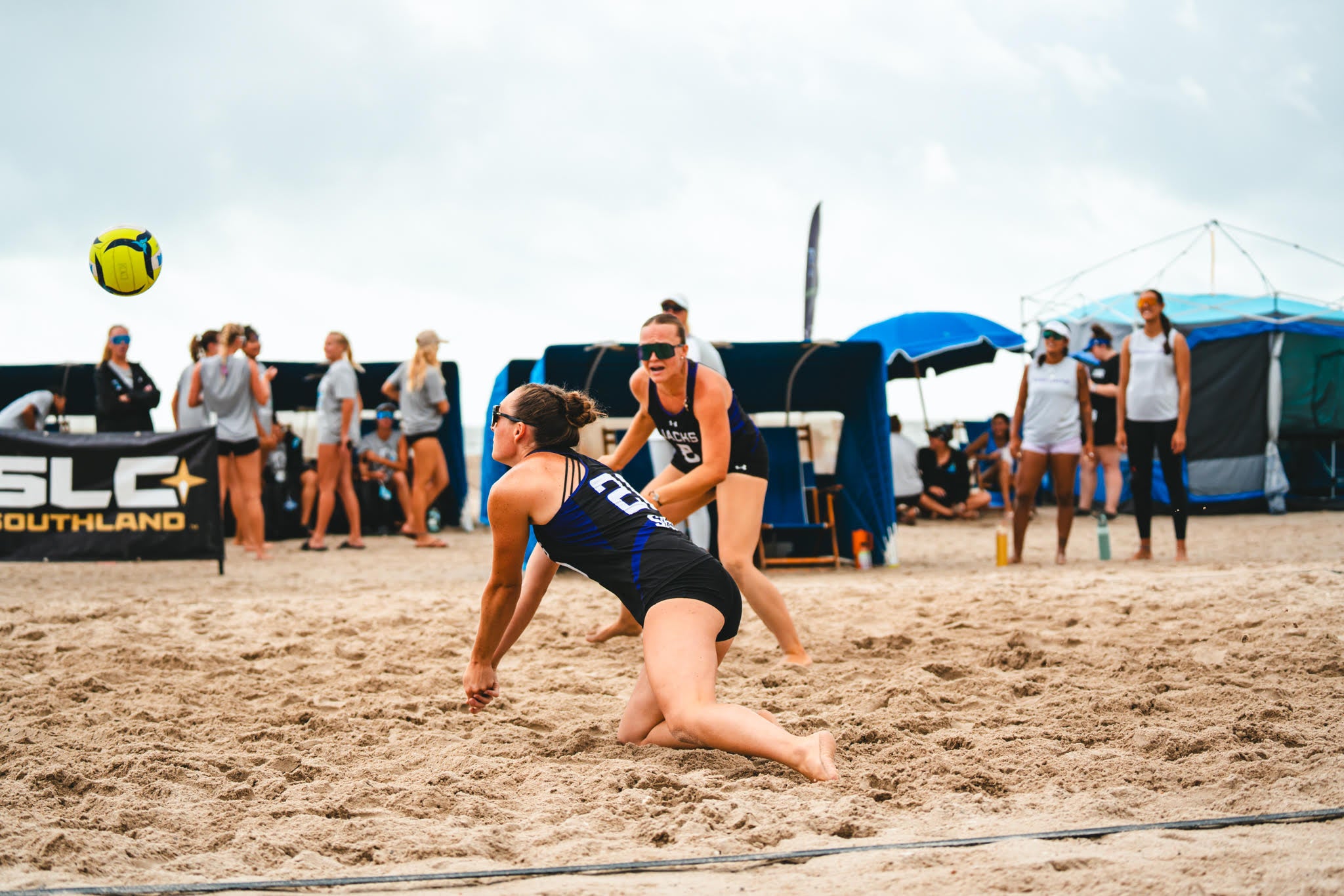 Two women playing beach volleyball.