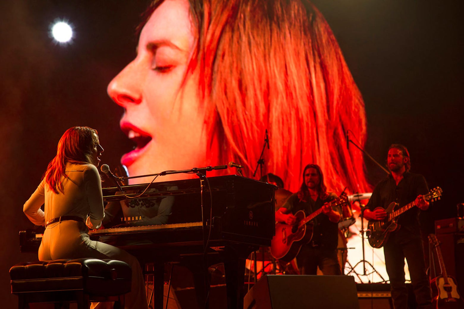 Lady Gaga at the piano and Bradley Cooper on guitar, performing on stage in A Star Is Born.
