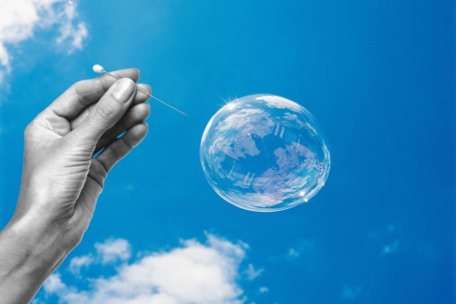Photo illustration: Someone popping a bubble with a pin.