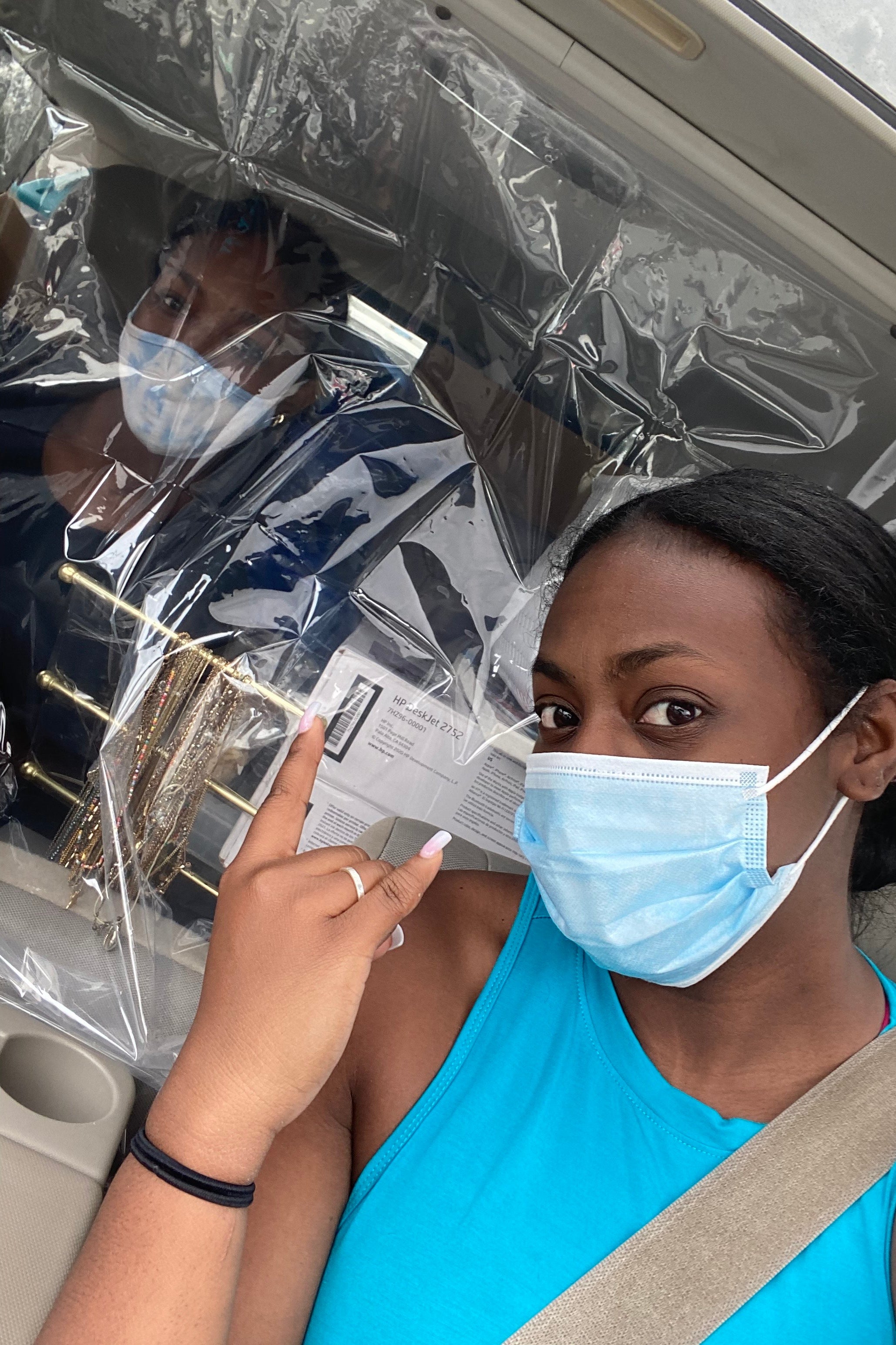 Jasmine Baker's sister sitting in the front of a car, with Jasmine in the back seat, a clear shower curtain between them.