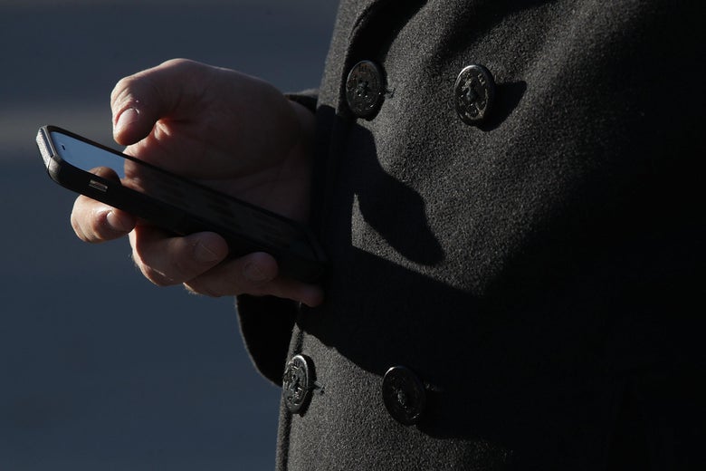 A hand holding a smartphone at waist level