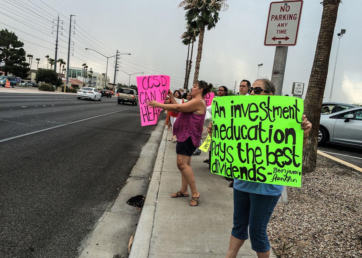 About 40 teachers protest a pay freeze for teachers in front of 